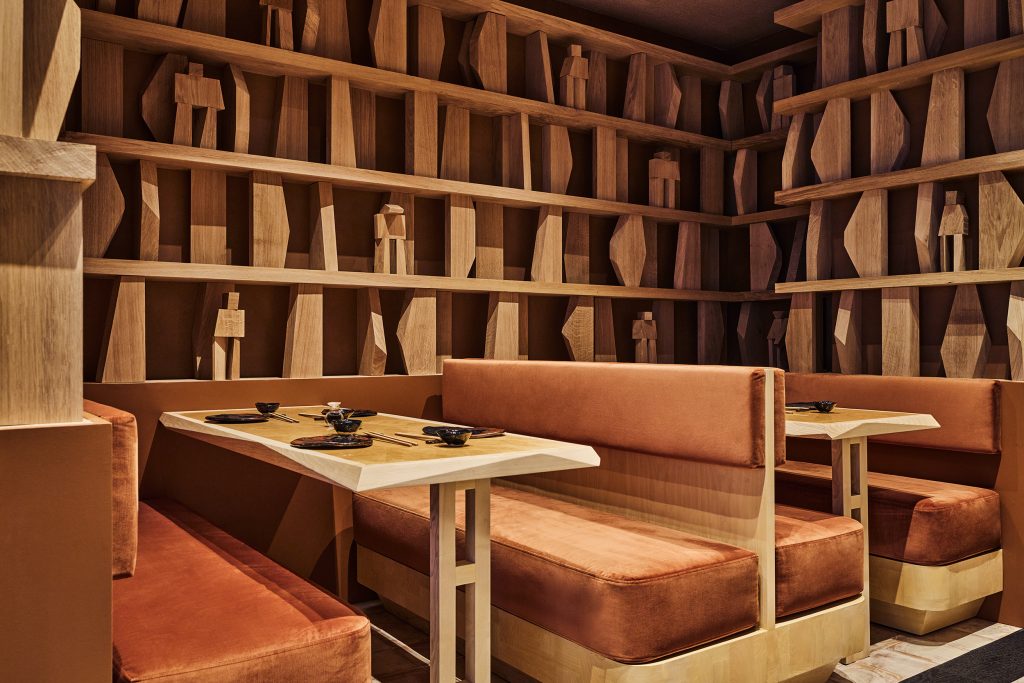 Restaurant Hando Paris bibliothèque en chêne massif habitée de samouraïs en bois qui structure la zone des banquettes imaginées par Jean-Guillaume Mathiaut